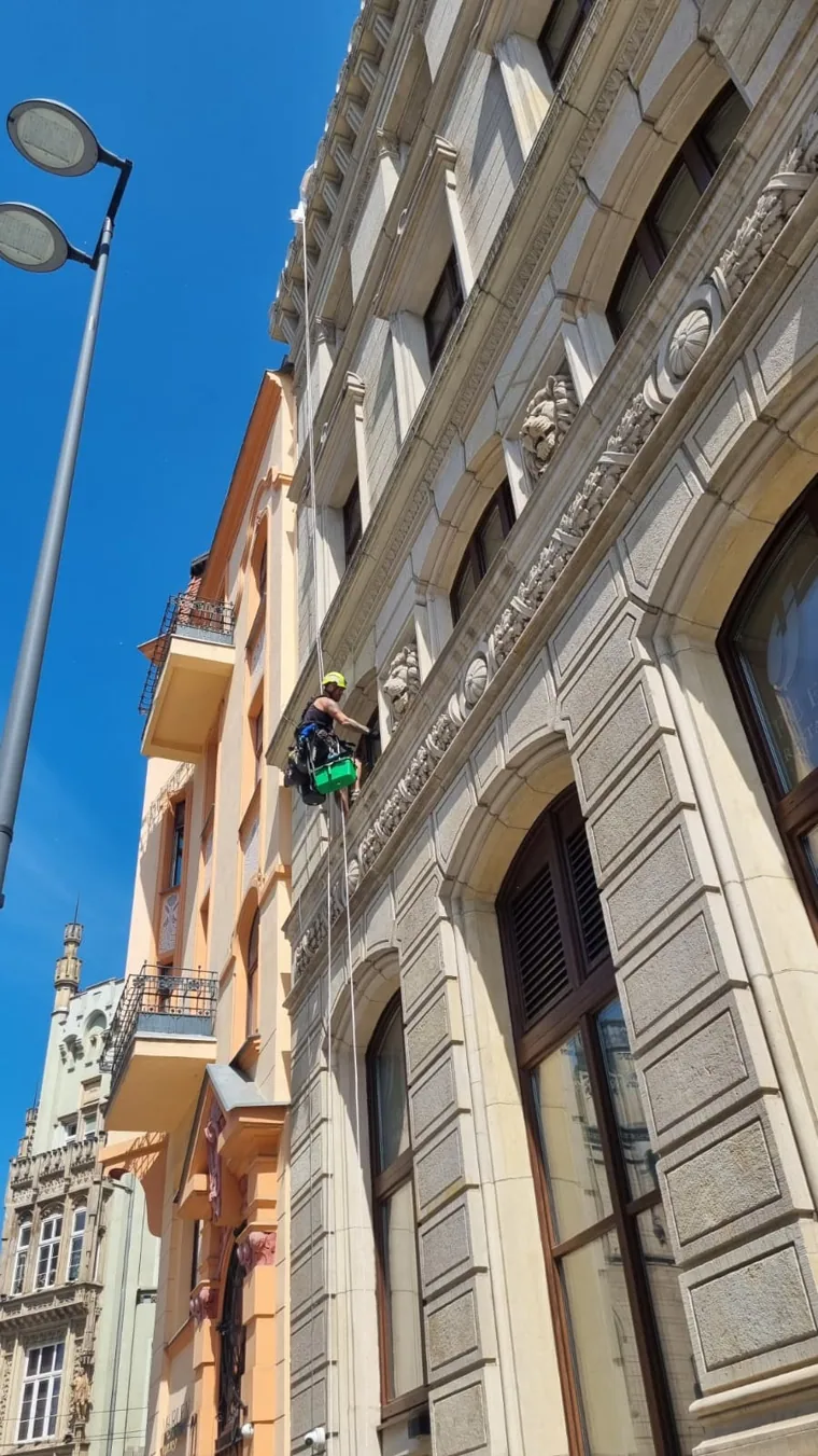 Prace na linach przy elewacji kamienicy